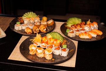 Refeição de sushi com vista zenital em mesa escura com espaço para texto © Matheus