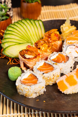 Refeição de sushi com vista zenital em mesa escura com espaço para texto © Matheus
