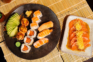 Refeição de sushi com vista zenital em mesa escura com espaço para texto © Matheus