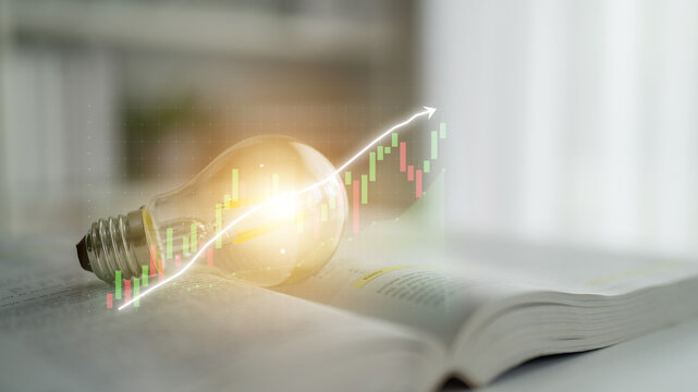 A light bulb rests on an open book, highlighting an overlay of a financial graph, representing the fusion of knowledge, creativity, and growth in various sectors. Impute