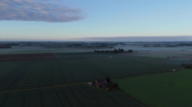 Aerial view of misty farmland at dawn