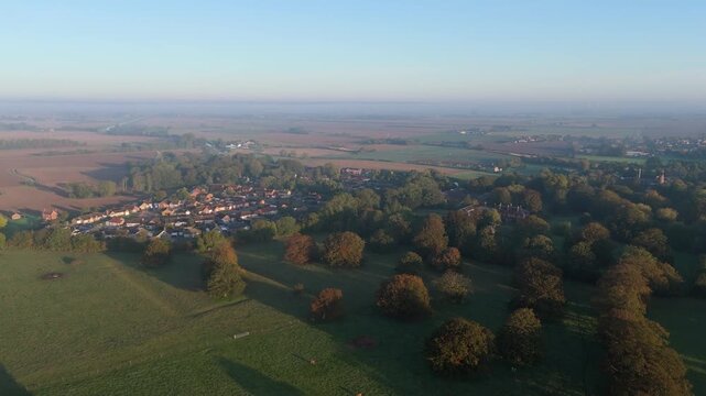 Golden morning light bathes quiet countryside village