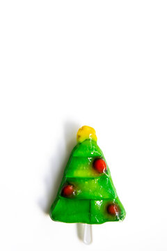 Close-Up of green Christmas Tree candy cake luk chup on white background, vertical, copy space. Traditional thai dessert in christmas tree shape. European holiday in South Eastern Asia