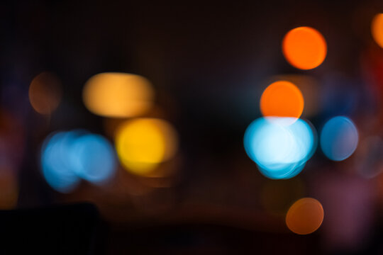Lens bokeh caused by close focusing on lights in a neighborhood bar restaurant to be an artful background image