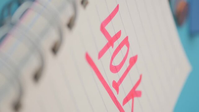 Pink marker text reading 401k on lined notebook paper focusing on retirement savings growth.