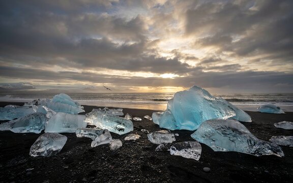 A stunning abstract composition of fractured icebergs under a dramatic ethereal sky evoking a sense of cold beauty