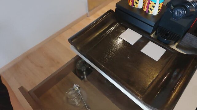 Modern Hotel Room Beverage Station with Coffee Maker and Glassware in Open Drawer.