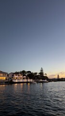 Fototapeta premium Waterfront Luxury Houses and Boats Along Canal at Sunset