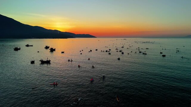 Radiant morning light touches the sea as local fishermen and people