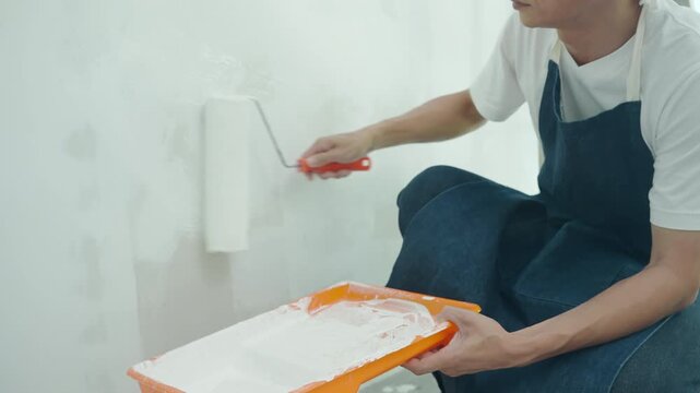 painter man, brush in hand for products to restore and paint the wall, indoor the building site of a house, wall during painting, renovation, painting, contractor, Architect, construction w