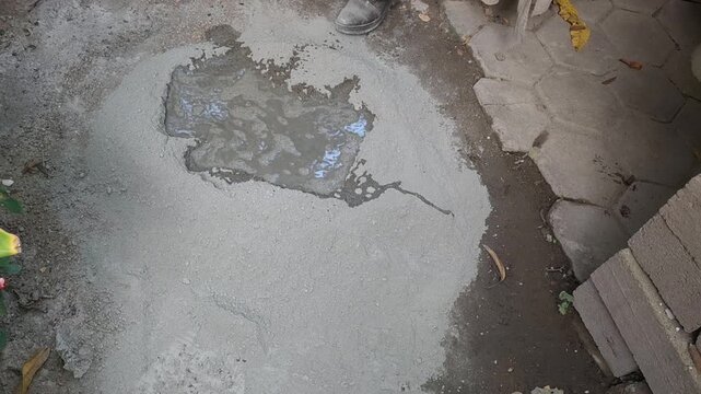 Pouring Water Into Dry Cement And Sand Mix For Mortar Preparation