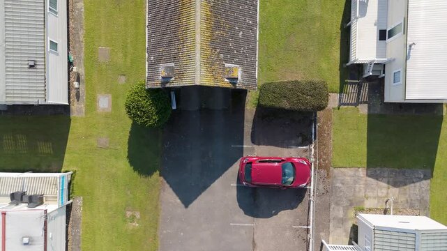 Drone hovers above green lawn and mobile homes