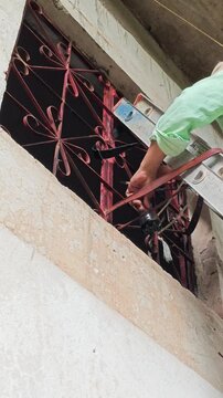 Close Up Hand Of Painter Applying Paint On High Window Frame