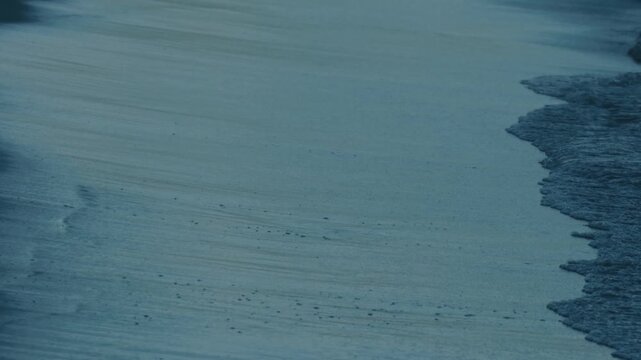 Close-Up of Gentle Waves Lapping Against a Dark Blue Shore