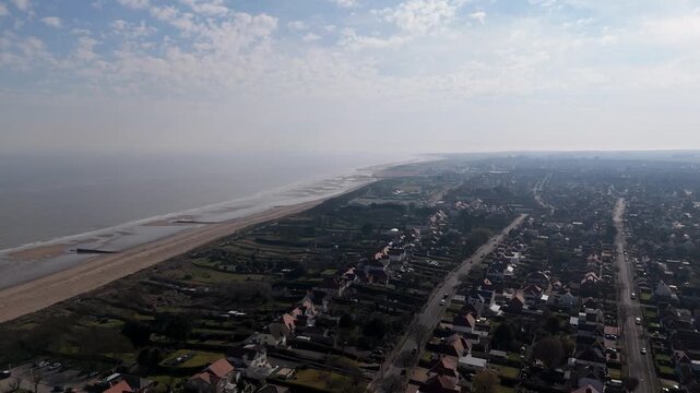 Aerial view of coastal town with calm sea and sandy beach