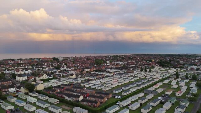 Aerial view shows caravan park near sea at golden hour