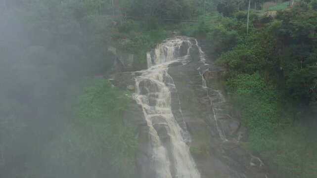 Aerial View of a Cascading Waterfall Shrouded in Mist