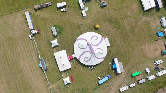 Aerial view of a large circular tent with purple swirls