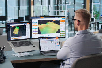Fototapeta premium Geologist Studies 3D Subsurface Data Using Laptop