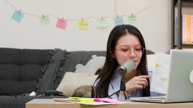 Asian Woman Recording Podcast With Microphone And Laptop At Home Desk
