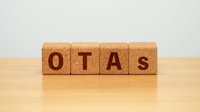 OTAs on four cork wooden blocks - online travel agencies concept