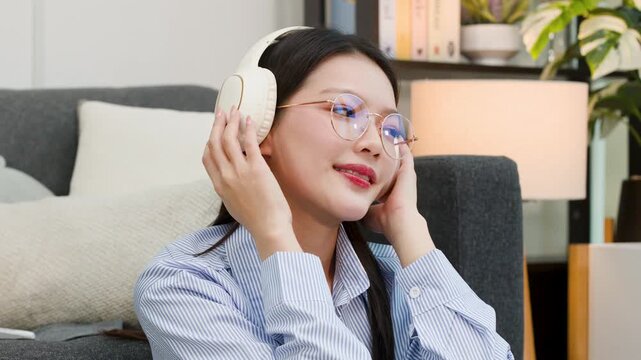 Young Asian Woman in Glasses Relaxing with Headphones at Home