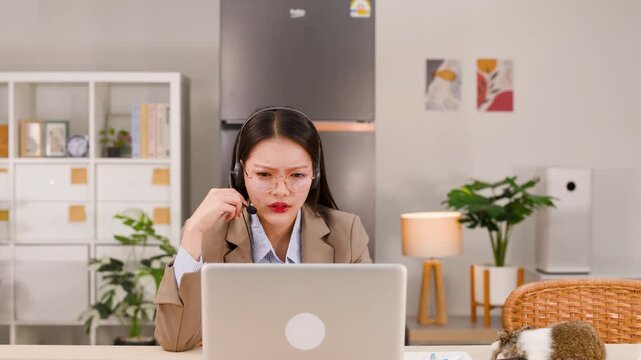 Frustrated Asian Businesswoman Having Video Conference Call on Laptop at Home