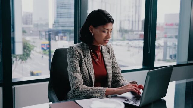 Laptop, typing and woman in office with paper for financial report, income statement or accounting. Reading document, computer and happy person in corporate enterprise, audit review or balance sheet