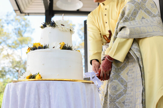 Traditional Malay Couple Cutting Wedding Cake