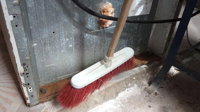 Sweeping Rust Particles Off Metal Stove Base With Brush