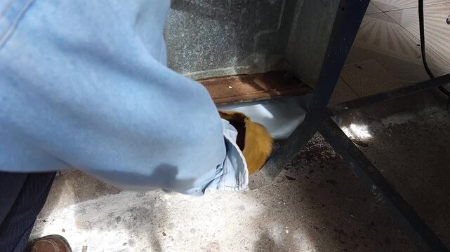 Placing Plastic Bag On Floor To Protect Surface Before Painting Stove Base