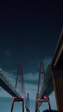 夜空の下で下から見上げる名港トリトン、奥行きのあるパースと迫力ある橋の夜景
