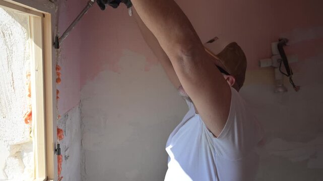 Construction worker applying polyurethane foam for window installation