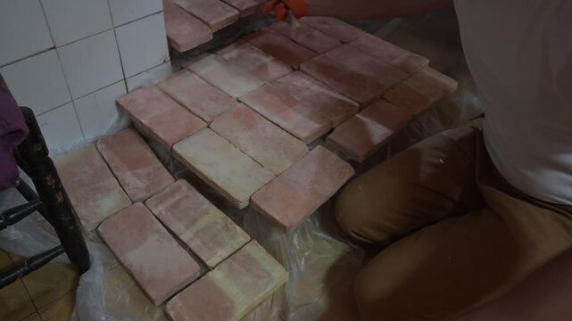 Man wearing gloves brushing decorative bricks at home