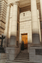 Fototapeta premium Stylish black woman leaving a grand courthouse building in the city