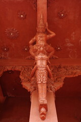 Fototapeta premium Ornate red mythological figure on a temple column