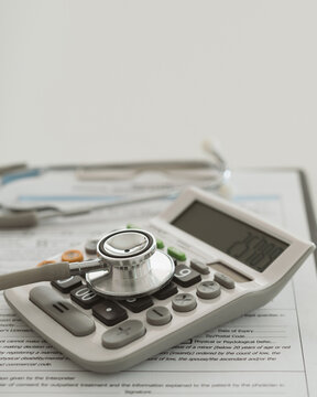 medical cost, stethoscope on calculator. concept of health care costs, finance, health insurance funds. vertical view.