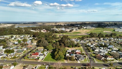 Naklejka premium Bairnsdale, Victoria, Australia – 4K aerial drone view of regional city centre, St Mary’s Catholic Church, Main Street, roundabouts, residential areas and East Gippsland countryside