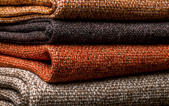 Textile design and interior decor, stack of rustic orange and brown fabric swatches with textured weave pattern for fashion and upholstery projects