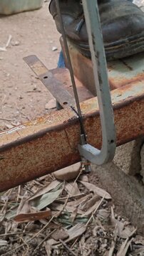 Hacksaw cutting rusted iron with oil