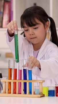 Little Girl in Lab Coat Conducting Science Experiment with Colorful Test Tubes