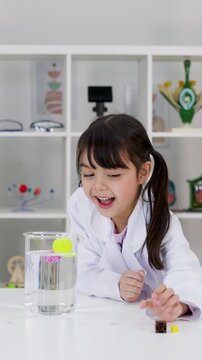 Little Girl in Lab Coat Conducting Science Experiment in Classroom