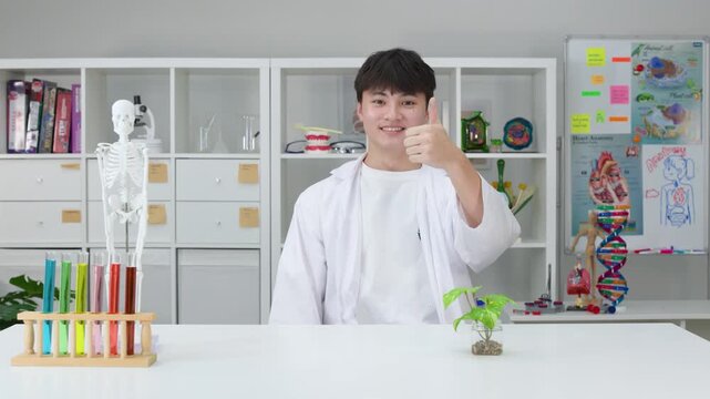 Smiling Teenage Student in Lab Coat Giving Thumbs Up in Science Classroom