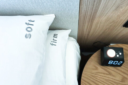 Firm and soft pillow alternatives placed on bed for hotel room guests to choose in accordance to preference for a comfortable sleep