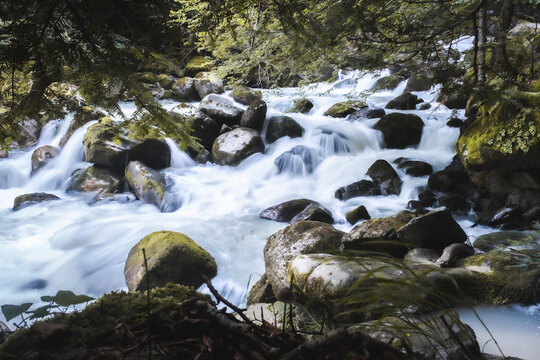 Senderismo por los bosques del Valle de Aran en lo pirineos. Efecto seda sobre cascada en r&iacute;o cerca Uelhs deth Jo&egrave;u