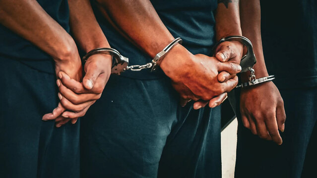 hands in handcuffs. the hands of several handcuffed inmates.