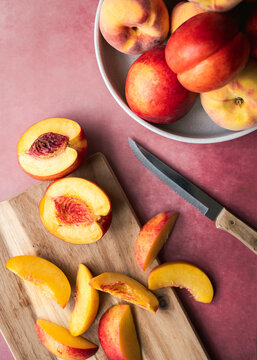 Fresh ripe peaches and nectarines sliced on a rustic cutting board
