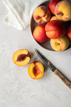 Fresh nectarines and peaches in a bowl one cut with a knife