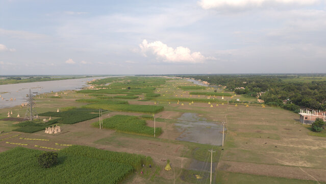 Aerial shot of vast green farmlands beside a river