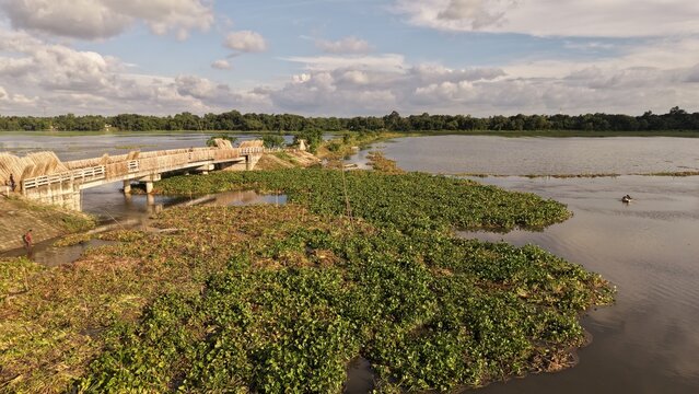 A bridge crosses a lush river landscape in the countryside